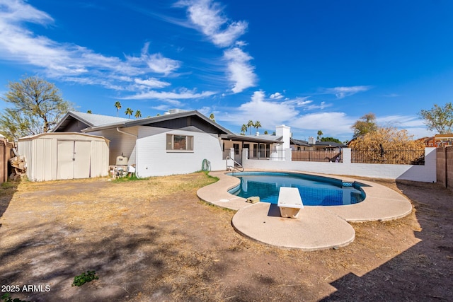 view of pool with a fenced in pool, an outbuilding, a fenced backyard, and a shed