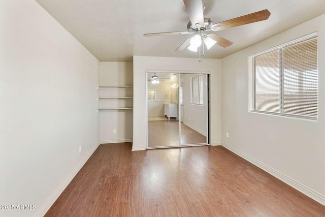 13245 N Betty Angel Way, Florence, AZ 85132 - unfurnished bedroom featuring multiple windows, wood finished floors, baseboards, and ceiling fan