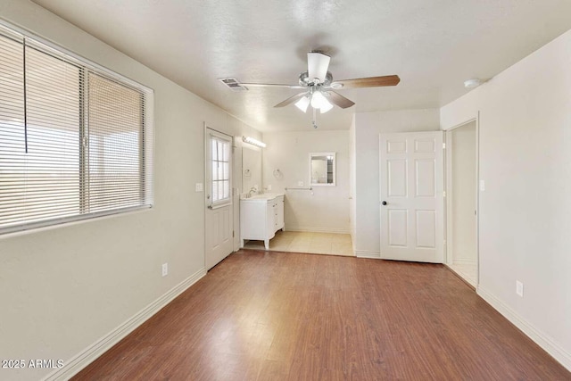13245 N Betty Angel Way, Florence, AZ 85132 - unfurnished living room featuring ceiling fan, wood finished floors, baseboards, and a sink