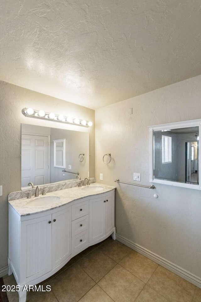 13245 N Betty Angel Way, Florence, AZ 85132 - bathroom featuring a textured ceiling, double vanity, tile patterned floors, and baseboards