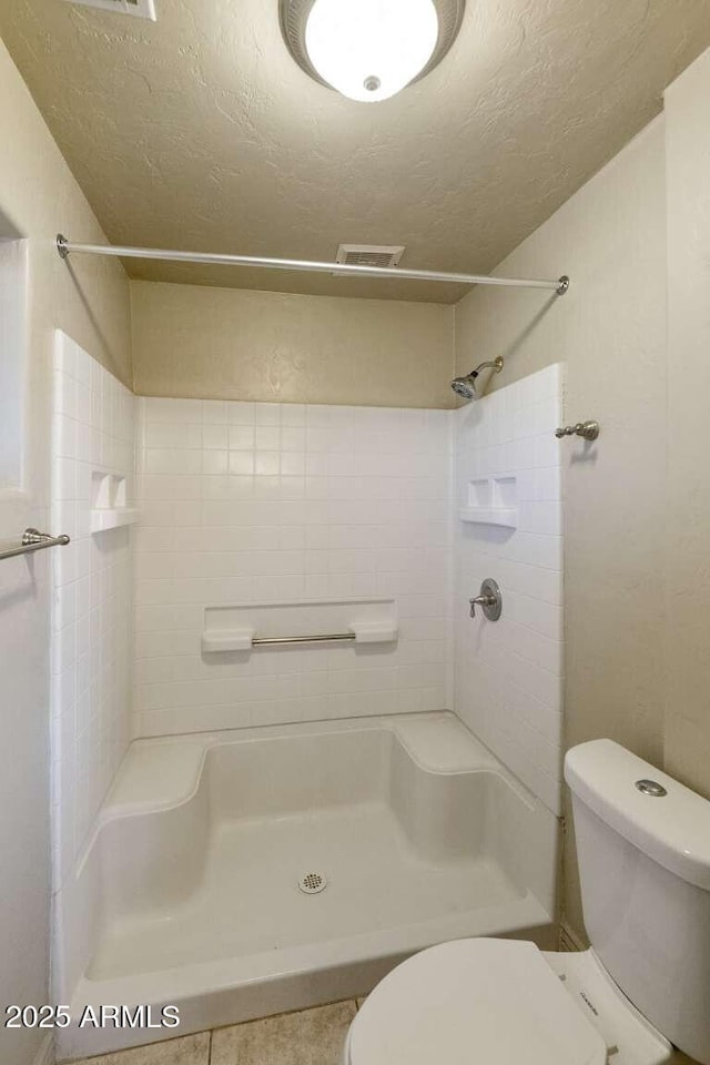 13245 N Betty Angel Way, Florence, AZ 85132 - bathroom with toilet, a textured ceiling, a shower, and tile patterned floors