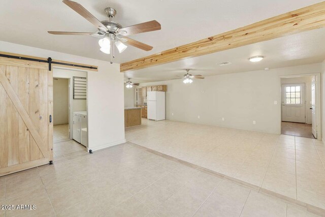 13245 N Betty Angel Way, Florence, AZ 85132 - unfurnished living room featuring a barn door, ceiling fan, light tile patterned flooring, and baseboards