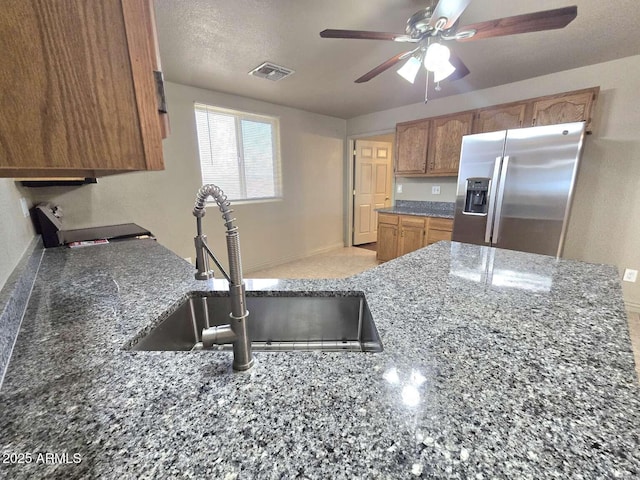 13245 N Betty Angel Way, Florence, AZ 85132 - kitchen featuring stainless steel fridge, a sink, a ceiling fan, dark stone counters, and baseboards