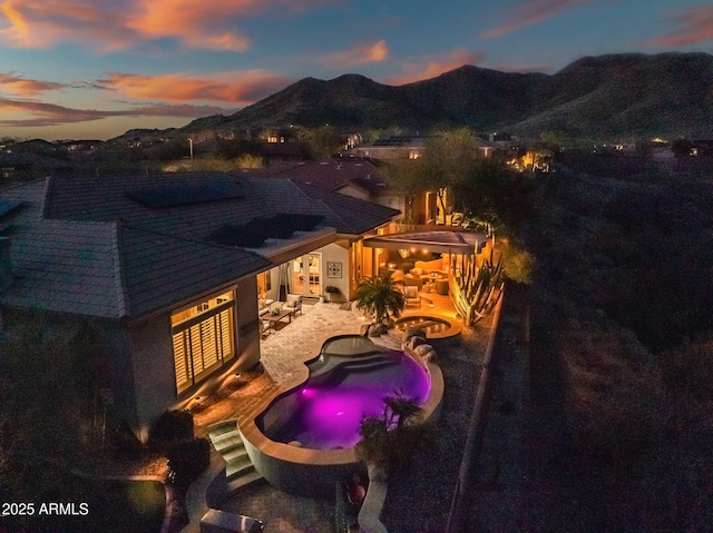 exterior space with outdoor lounge area, a patio, an outdoor pool, and a mountain view