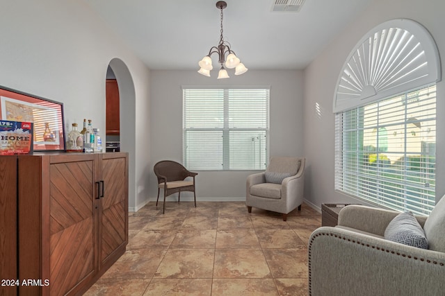 living area with light tile patterned floors and an inviting chandelier