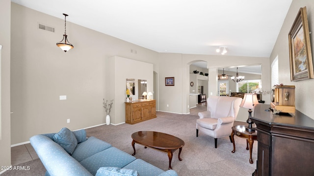 carpeted living room with visible vents, arched walkways, an inviting chandelier, and vaulted ceiling