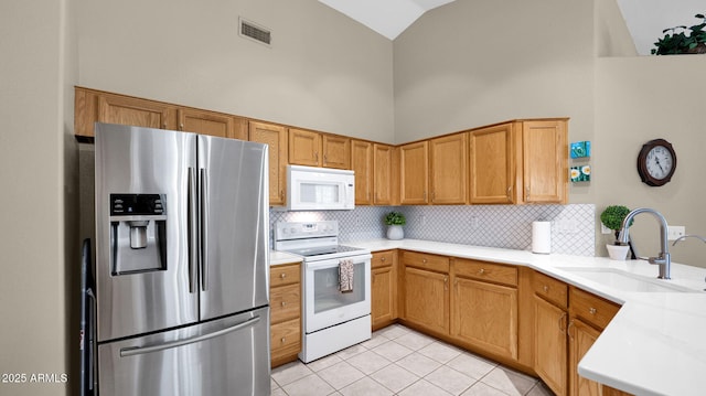 kitchen with high vaulted ceiling, a sink, white appliances, light tile patterned flooring, and light countertops