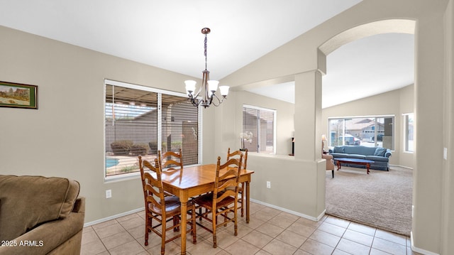 dining area with a chandelier, light tile patterned floors, a wealth of natural light, and lofted ceiling