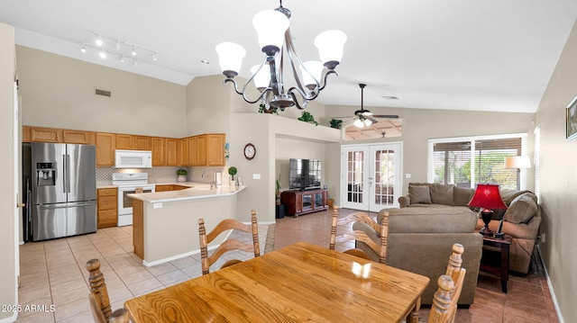 dining space featuring light tile patterned floors, ceiling fan with notable chandelier, visible vents, and french doors