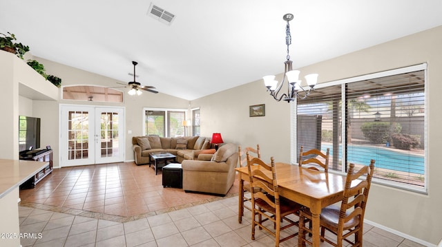 dining room featuring visible vents, ceiling fan with notable chandelier, french doors, light tile patterned floors, and lofted ceiling