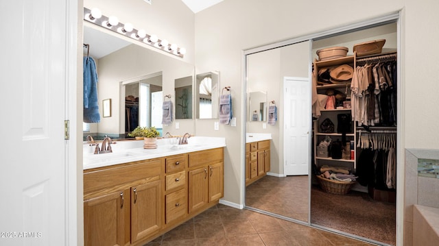 full bath with a sink, a walk in closet, double vanity, and tile patterned floors