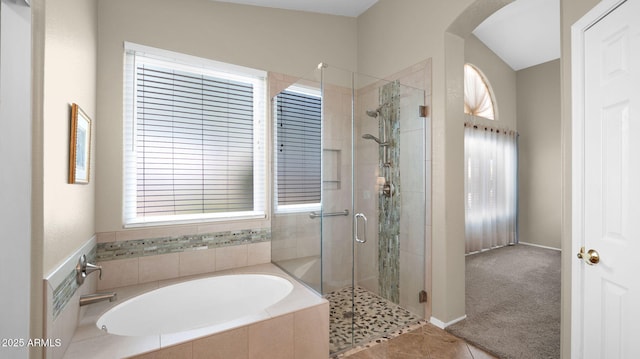 full bathroom featuring a wealth of natural light, a stall shower, and a garden tub