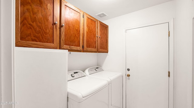 laundry area with visible vents, cabinet space, and separate washer and dryer