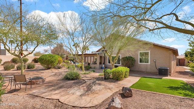 exterior space with a patio area, fence, central AC, and a fire pit