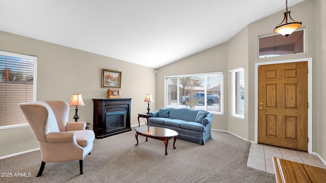 living room with lofted ceiling, a glass covered fireplace, light tile patterned floors, baseboards, and light colored carpet