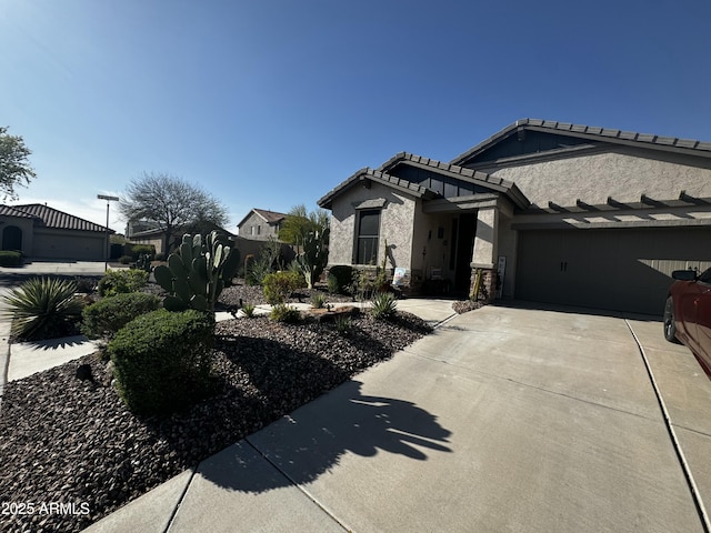 view of front of home with concrete driveway, stucco siding, a garage, and a tile roof