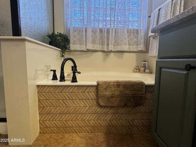 bathroom featuring tile patterned flooring, a bath, and a healthy amount of sunlight