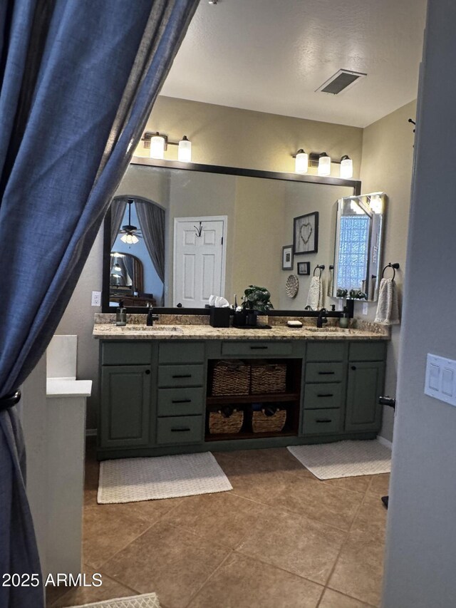 bathroom with double vanity, visible vents, tile patterned flooring, and a sink