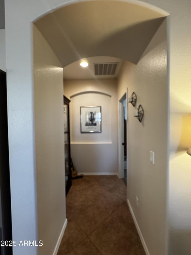hall featuring dark tile patterned floors, baseboards, visible vents, and recessed lighting