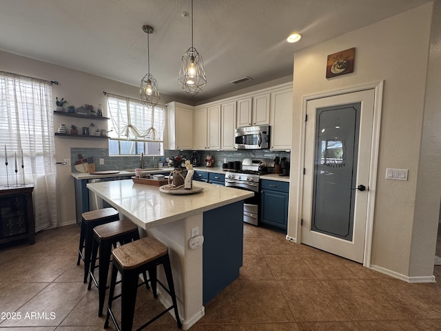 kitchen featuring stainless steel appliances, visible vents, decorative backsplash, and blue cabinets