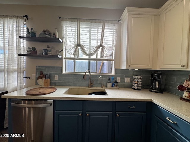 kitchen featuring a sink, stainless steel dishwasher, backsplash, and light countertops