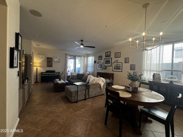 dining room with a textured ceiling and ceiling fan with notable chandelier