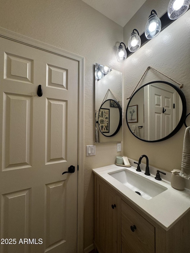 bathroom featuring vanity and a textured wall