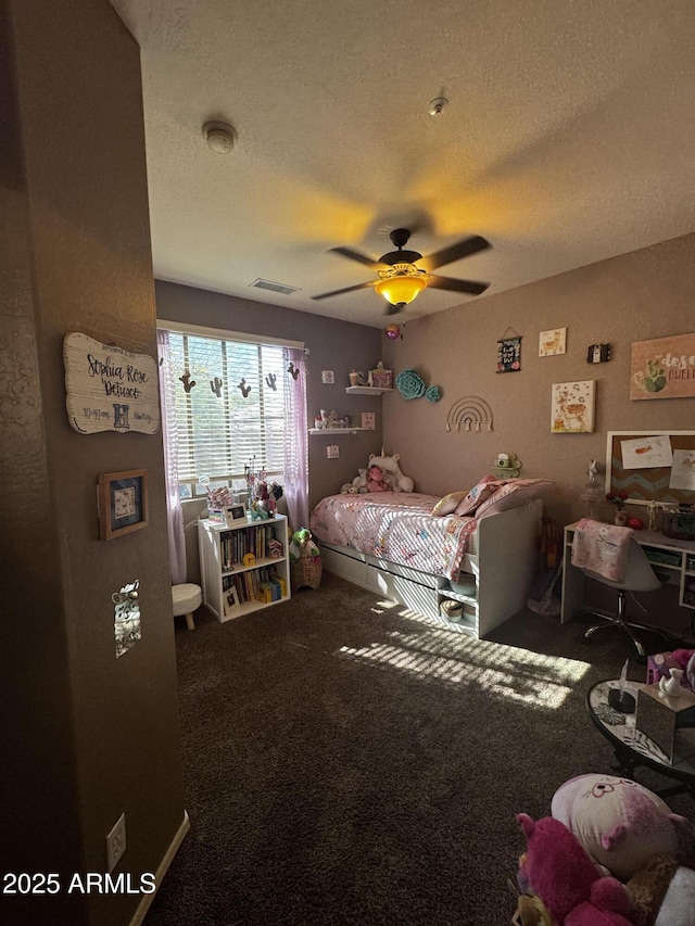 carpeted bedroom with a textured ceiling, a ceiling fan, and visible vents