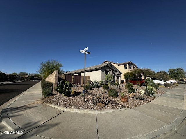 view of side of property featuring fence and stucco siding