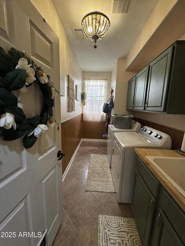 laundry area featuring dark tile patterned floors, cabinet space, a wainscoted wall, visible vents, and independent washer and dryer