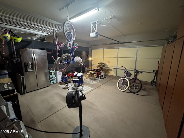 garage featuring stainless steel fridge and a garage door opener