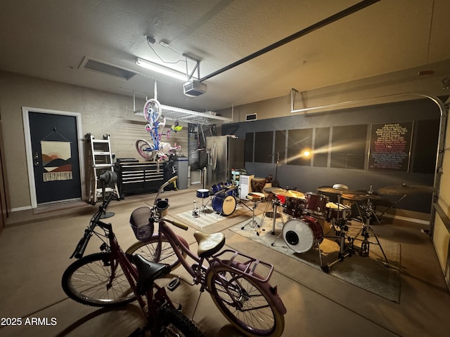 garage featuring stainless steel fridge and a garage door opener