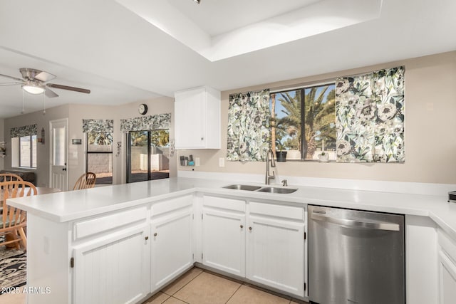 kitchen featuring kitchen peninsula, stainless steel dishwasher, white cabinetry, and sink