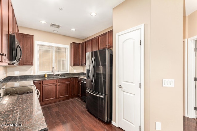 kitchen featuring dark stone countertops, sink, and stainless steel appliances