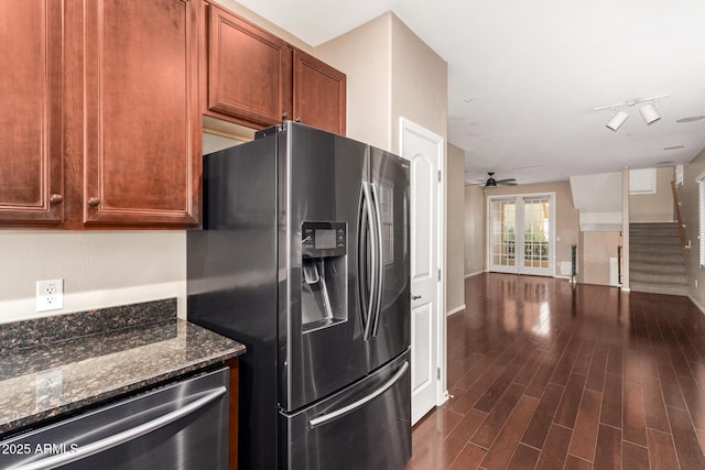 kitchen featuring dark stone counters, track lighting, french doors, dark hardwood / wood-style floors, and appliances with stainless steel finishes