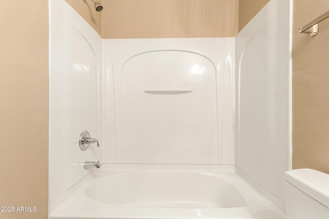 bathroom featuring toilet and bathing tub / shower combination