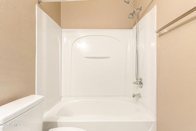 bathroom with shower / bathing tub combination and toilet