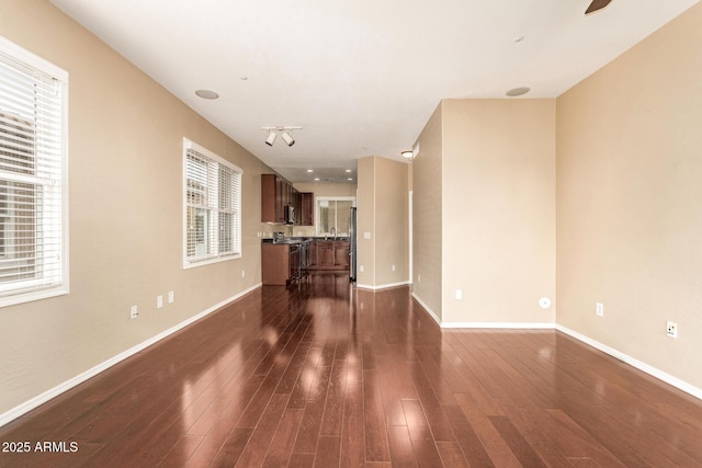 unfurnished living room featuring dark hardwood / wood-style flooring and plenty of natural light