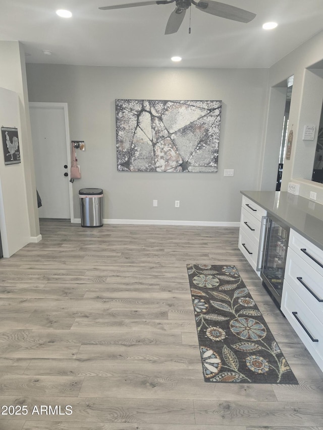 kitchen featuring beverage cooler, wood finished floors, white cabinetry, and recessed lighting