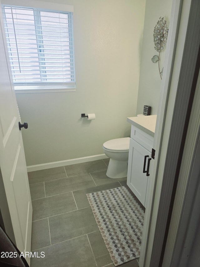 bathroom featuring tile patterned flooring, toilet, vanity, and baseboards