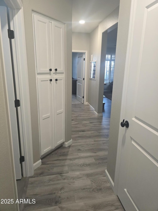 corridor with dark wood finished floors and baseboards