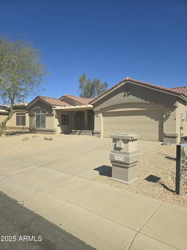 view of front of property featuring a garage, concrete driveway, a tile roof, and stucco siding