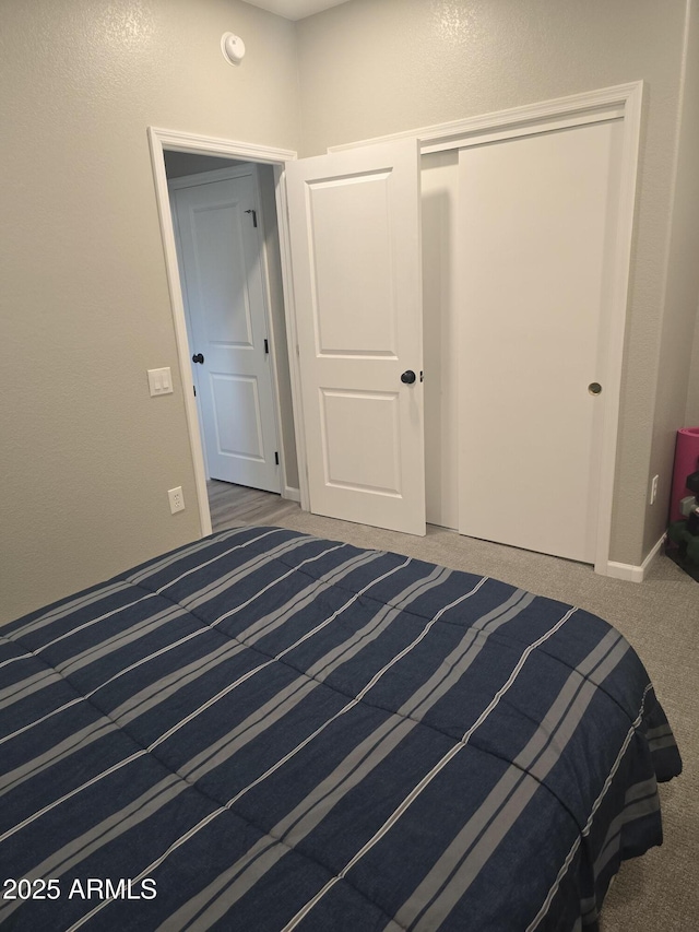 unfurnished bedroom with carpet floors, a closet, and baseboards