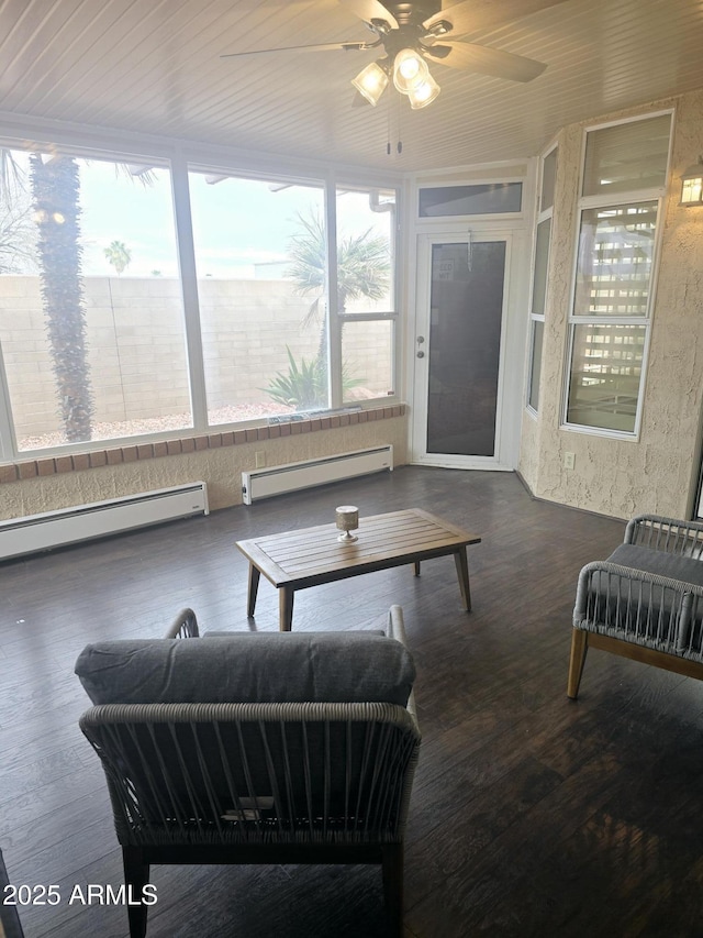 living room with a baseboard heating unit, wood finished floors, and a sunroom