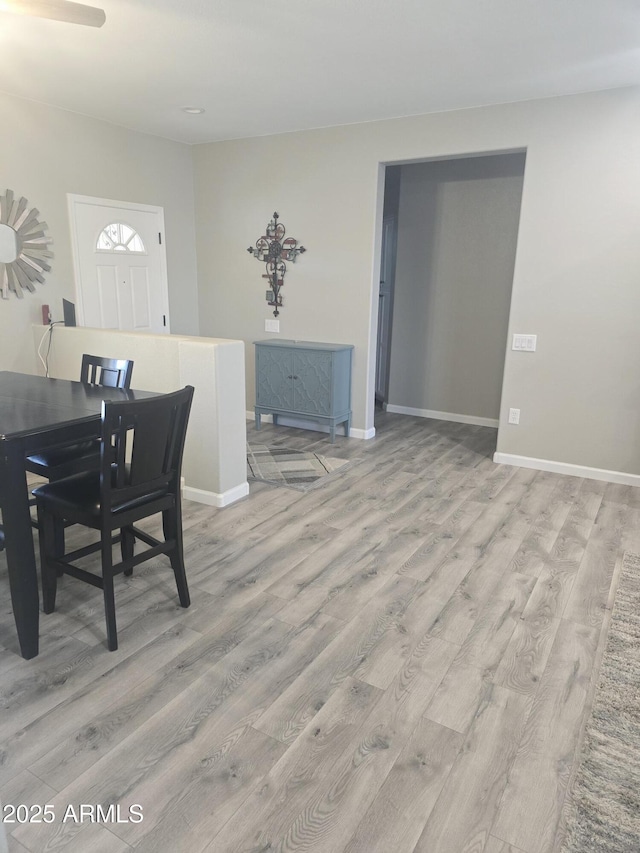 dining area with light wood-type flooring and baseboards