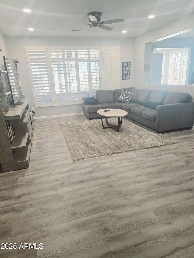 living area with recessed lighting, ceiling fan, baseboards, and wood finished floors