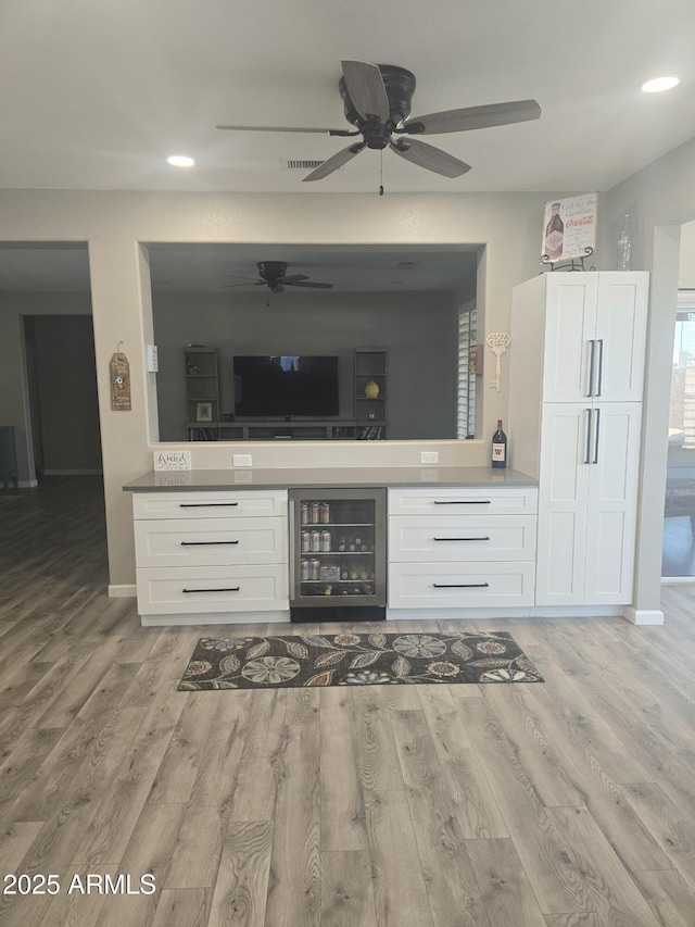 kitchen featuring beverage cooler, white cabinets, and light wood finished floors