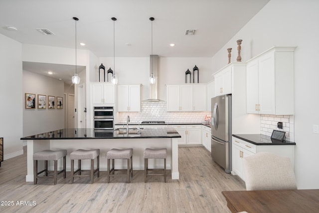 kitchen with dark countertops, visible vents, appliances with stainless steel finishes, and a sink