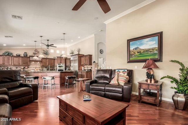 living room featuring ceiling fan, crown molding, visible vents, and dark wood-style flooring