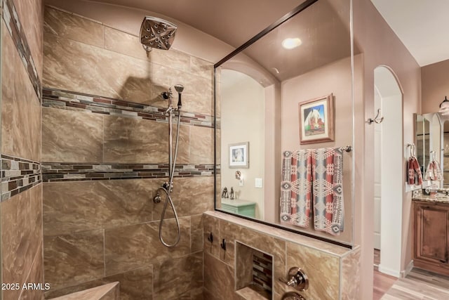 full bathroom featuring a walk in shower, wood finished floors, and vanity